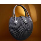 Stylish round lady golf handbag with modern textured design, combining sporty aesthetics with a bold, fashion-forward shape.